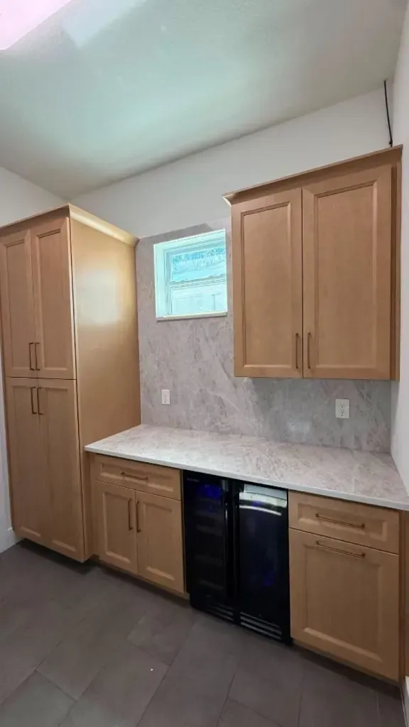 Oak wet bar with shaker cabinets and a stone counter