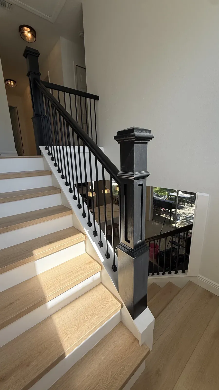 Staircase with oak treads, white risers, black balusters, and a black newel post Staircase with oak treads, white risers, black balusters, and a black newel post