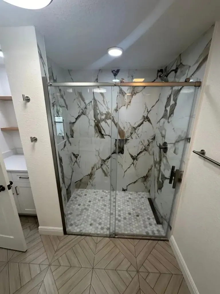 Marble-look walk-in shower with a frameless glass panel Marble-look walk-in shower with a frameless glass panel