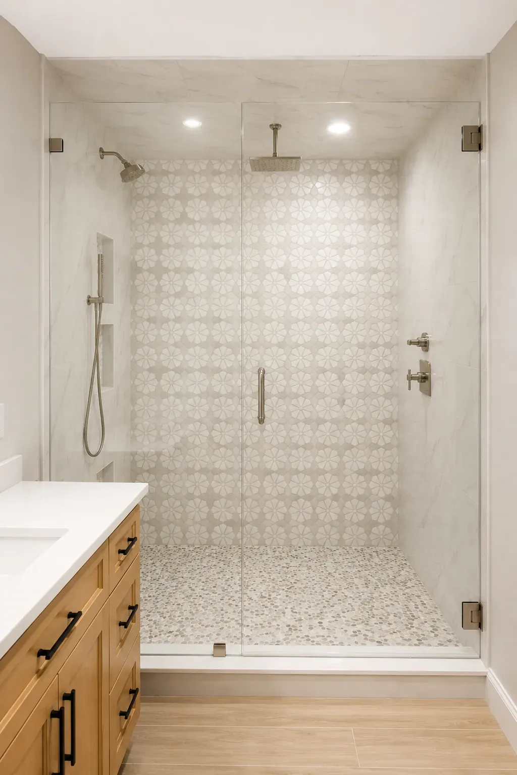 Walk-in shower with patterned wall tile, a pebble floor, and a frameless glass door Walk-in shower with patterned wall tile, a pebble floor, and a frameless glass door